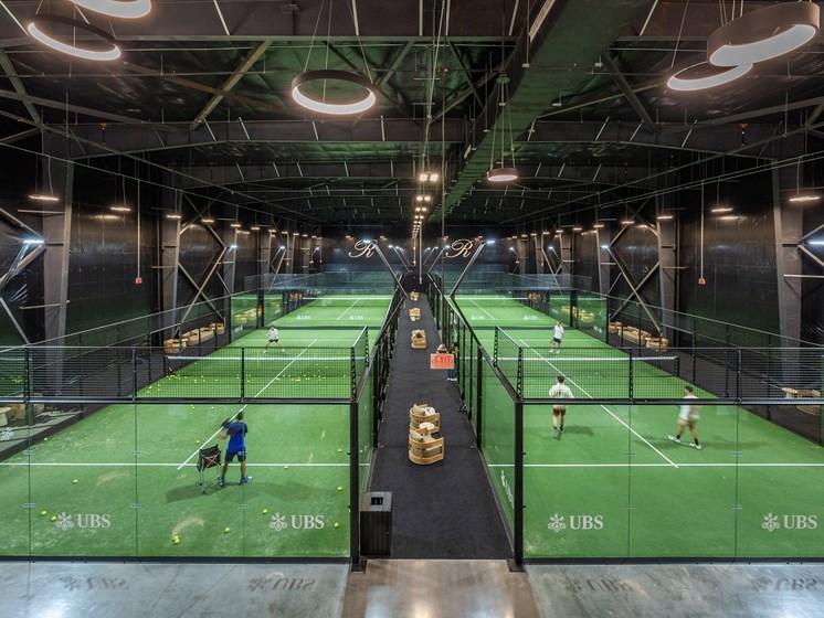 A tennis court with players and a net.